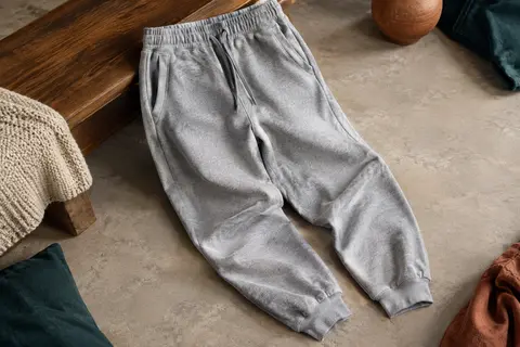 Pantalon de jogging en coton gris clair chiné, avec cordon de taille, poches latérales et chevilles côtelées.